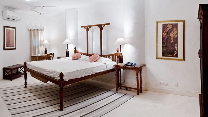 Hill Fort Kesroli 14th Century Alwar - interior view of the Jai Mahal Room with queen size bed and lamps illuminating the walls on either sides of the bed