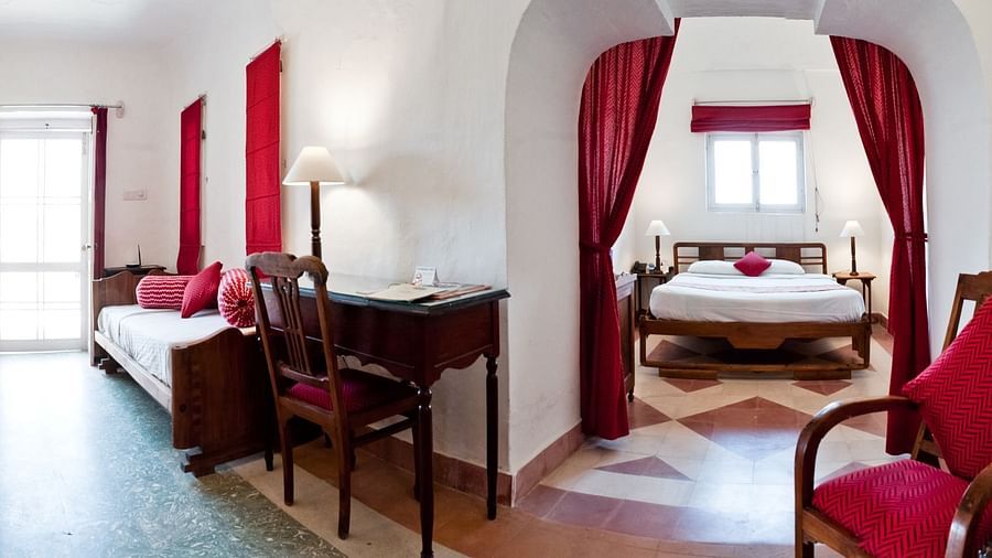 Hill Fort Kesroli 14th Century Alwar - interior view of the Shri Mahal - Village View with a king size bed and red curtains