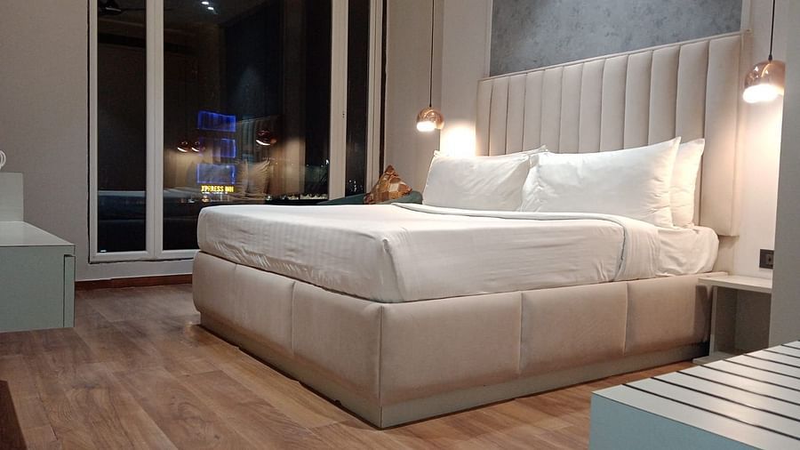 Spacious bedroom with double bed and seating area at Sapna Clarks Inn.