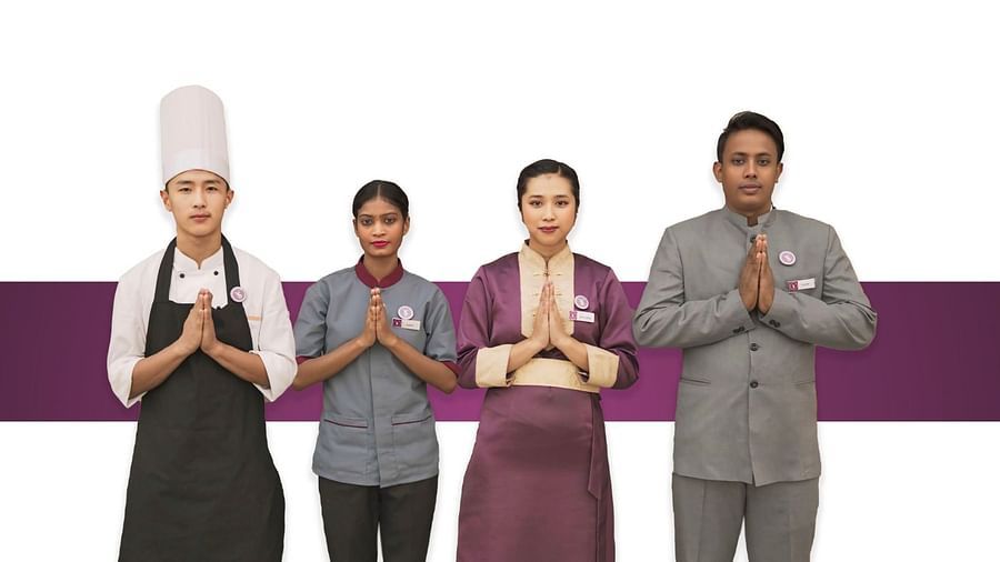 An image of four people joining hands to wlecome guests - Sumi Yashshree Hotels & Resorts