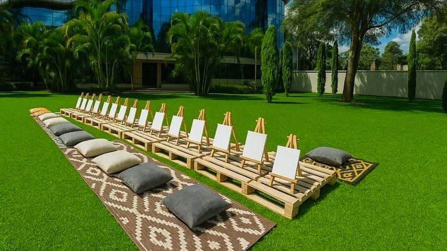 A row of blank canvases set up outdoors at The Boma Nairobi, with floor cushions neatly placed in front.