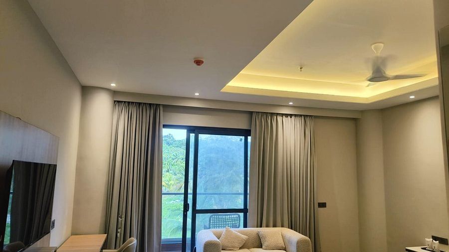 Bright and spacious Superior Forest View Room at Silver Sand Sea Princess Beach Resort with ceiling lighting, large window with curtains, sofa seating, and a view of greenery through the glass door