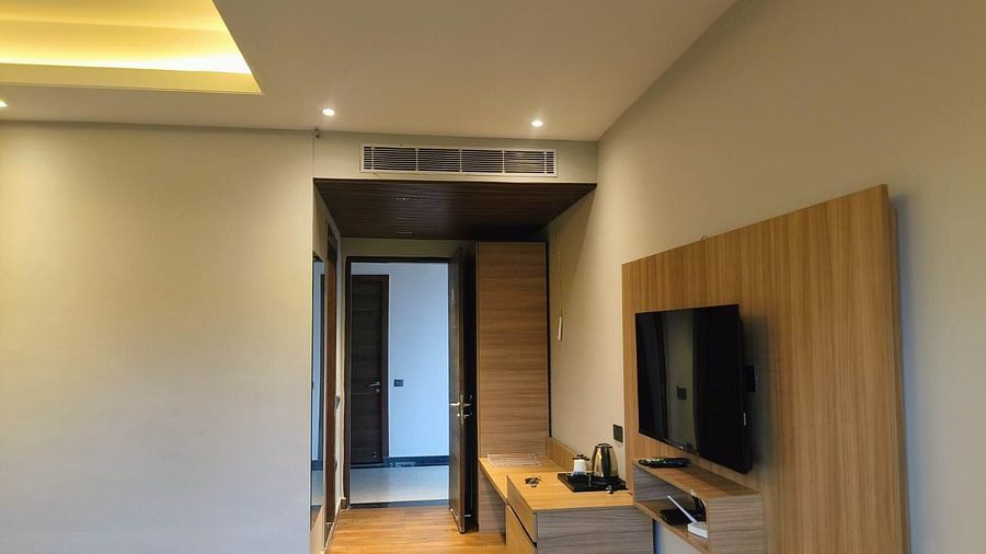 Superior Forest View Room at Silver Sand Sea Princess Beach Resort with interior featuring a wall-mounted flat-screen television, wooden desk with chair, soft lighting, and a doorway leading to an adjoining space