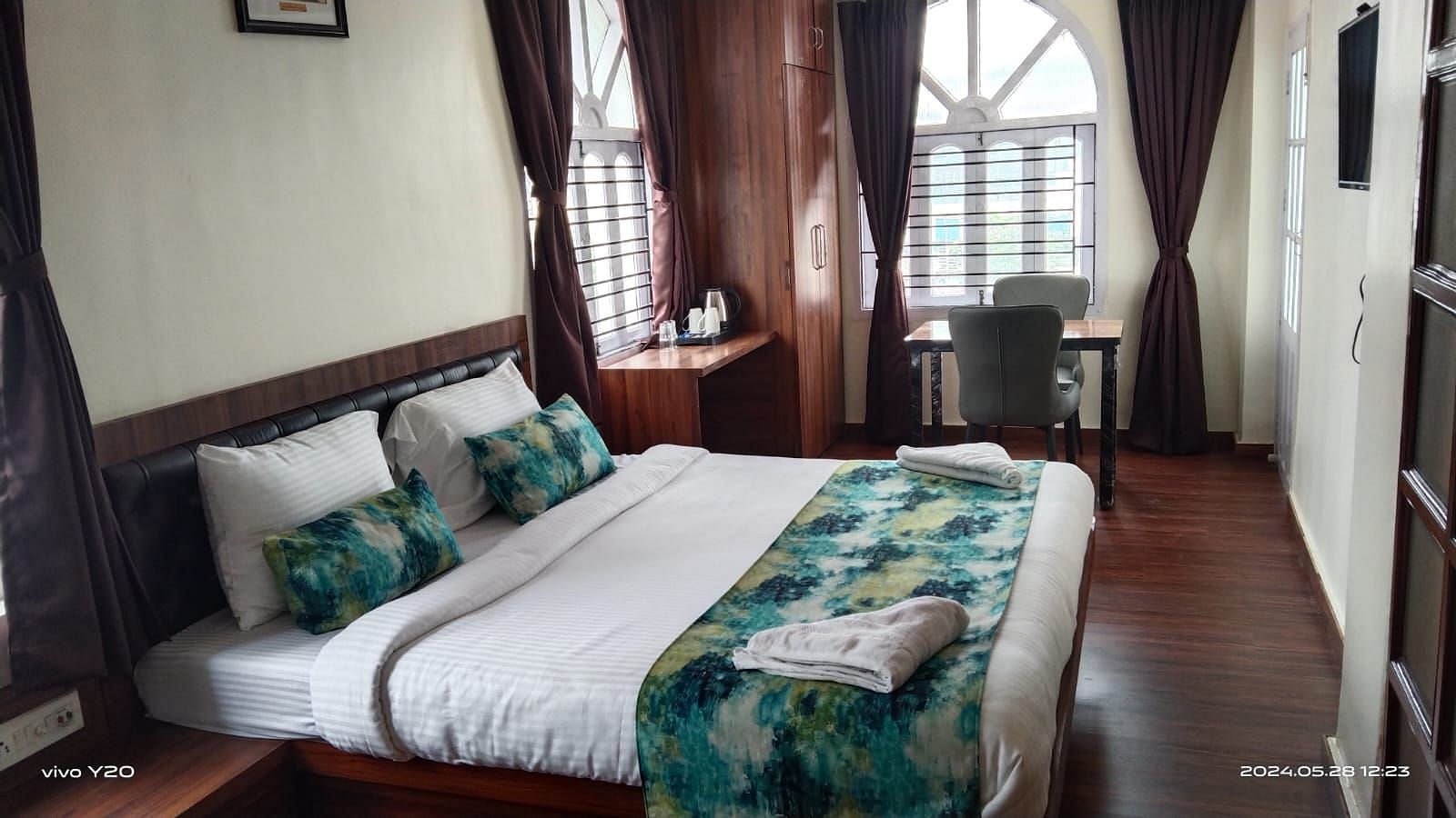 A double bed with towels kept on them inside Premium room with balcony - Ecotel Kolkata