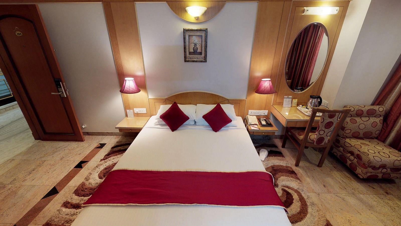 The superior room at Hotel Pai Viceroy Jayanagar featuring a queen size bed with white linen and a maroon runner