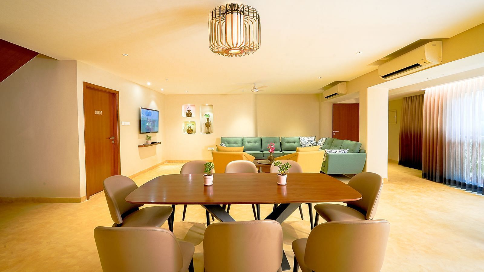 Modern dining area at Vasundhara Villa featuring a large dining table, ambient lighting, and family-friendly space.