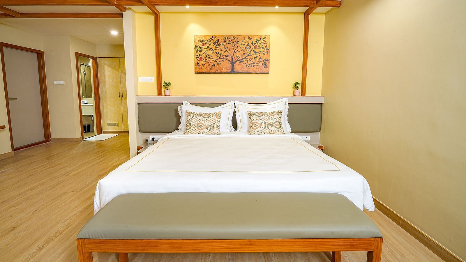 Spacious king-size bedroom at Vasundhara Villa, Ramoji Film City with warm lighting and elegant décor.