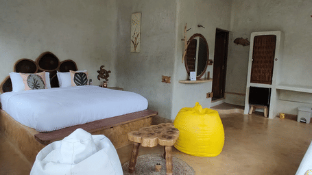 Spacious eco-luxury room at Matsya Island Retreat, Havelock featuring a cozy king bed, rustic decor, and comfortable seating for a relaxing island stay.
