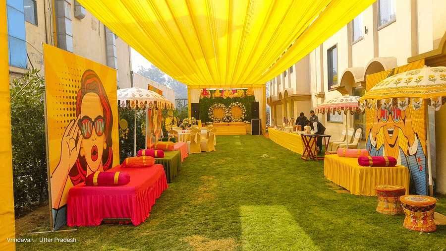 Brij Eternity, Vrindava |  A vibrant, open-air setup with bright yellow drapes and festive décor for pre-wedding rituals.