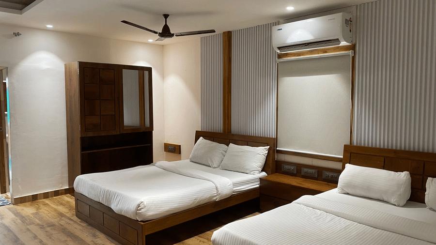 Modern bedroom featuring two double beds with white linens and minimalist decor - DAN Resorts & Weddings, Palghar