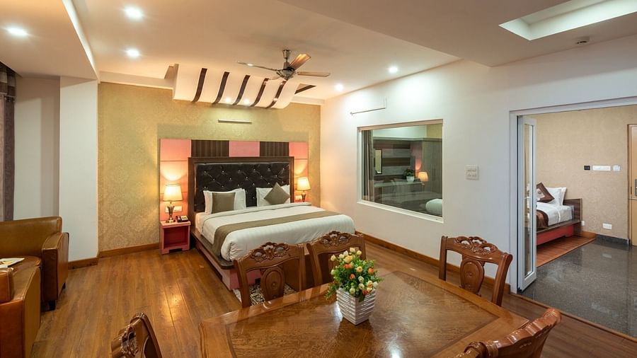 Dining area and double bed of the Family Suite of DLS Hotel Shiva Sanctuary & Spa in Dharamshala.