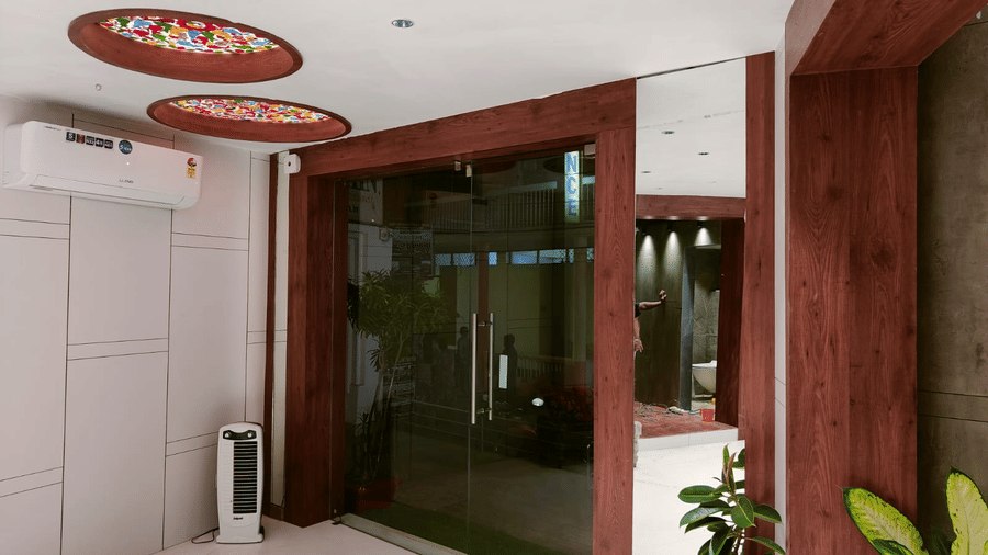 A modern hotel interior lobby area with wooden panelling, a patterned ceiling, and a view into a dimly lit space - Hotel Dolphin Puri