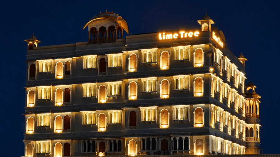 A close-up night view of the illuminated multi-storey building facade and architectural details at Lime Tree Hotel & Banquet, Jaipur.