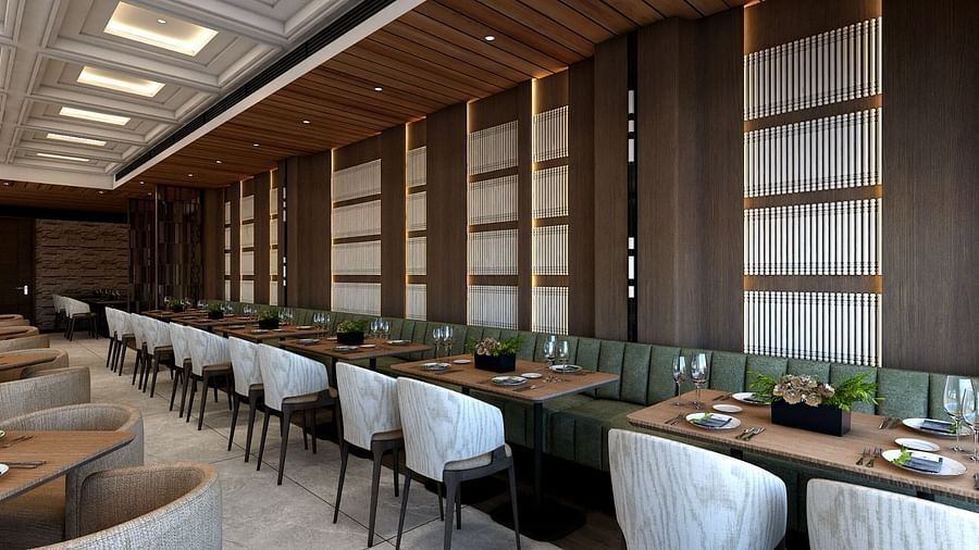 A long green coloured sofa lined with several dining tables along with grey coloured cushioned chairs - Namaste Corbett