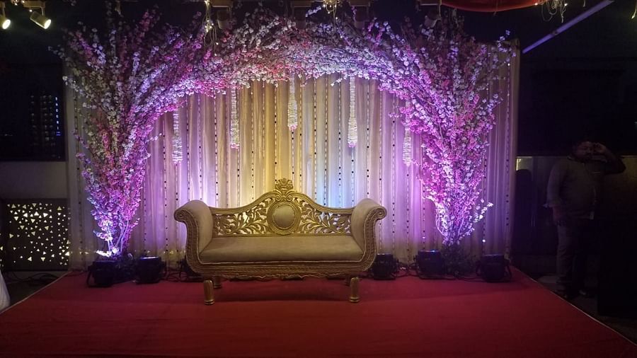 Image of a stage with a sofa and a backdrop of plants and lights at The Oriental Residency