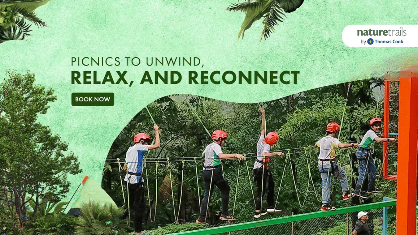 Promotional banner featuring a group of people passing by a rope bridge amidst the jungle. The banner says book a picnic at Nature Trails Resort which can help unwind, relax, and reconnect.