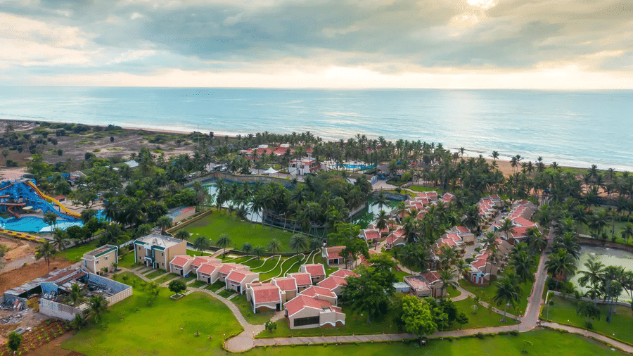 An aerial view showing the extensive green grounds, resort buildings, and beachfront of the entire MGM Beach Resorts, ECR Chennai property.