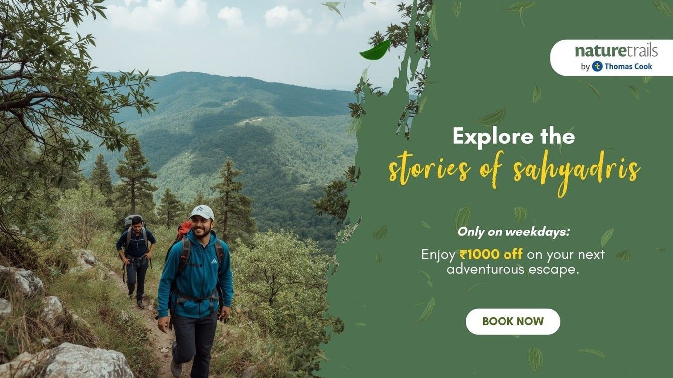Two hikers walking along a forested mountain trail in Sakleshpur with a promotional banner offering ?1000 off on bookings at Nature Trails Resorts