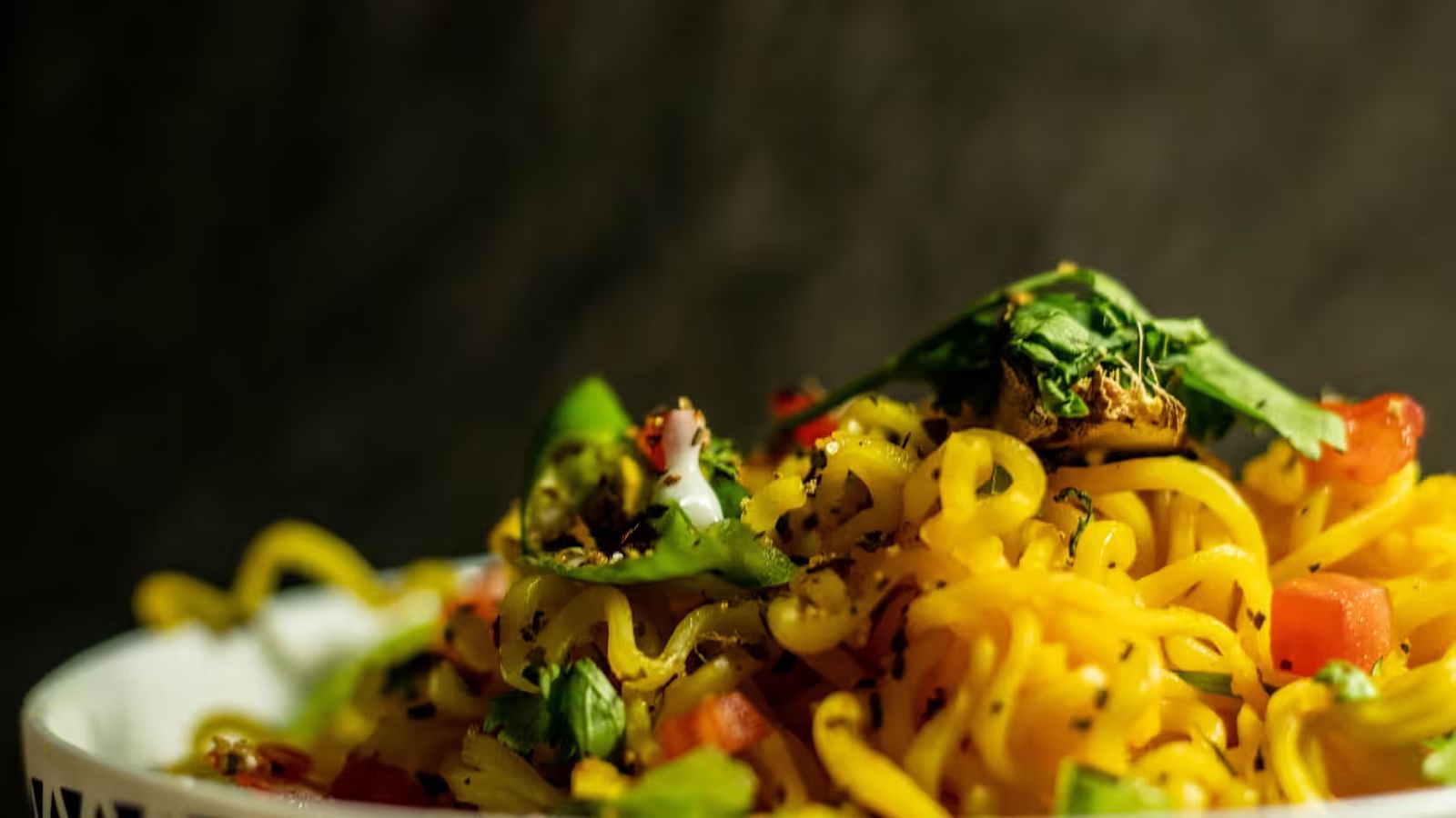  Noodles in a bowl, topped with vegetables.
