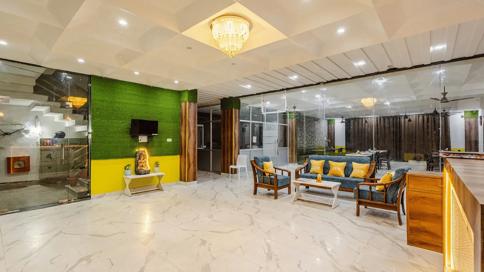 A hotel lobby with seating area, green accent wall, and chandelier lighting - Lime Tree Hotels & Banquet, Vrindavan