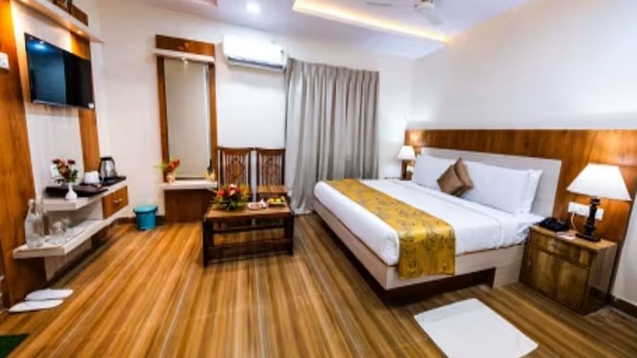  A spacious room with a large bed, wooden bedside tables on either side, and a wall-mounted television facing the bed.