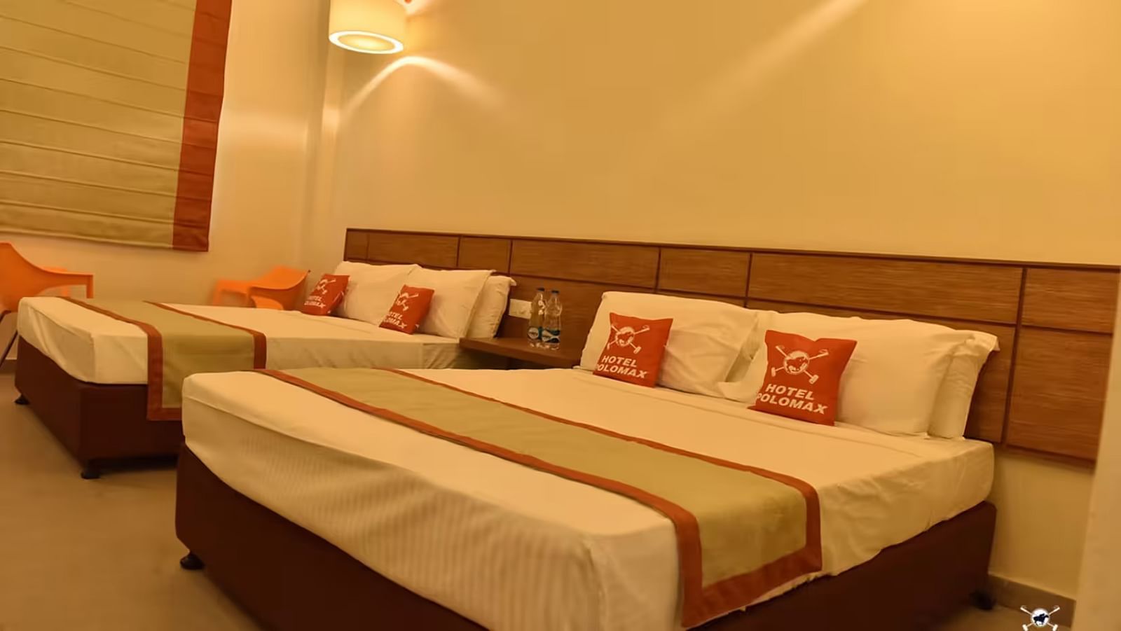 View of a hotel room with multiple beds, soft lighting, and cosy interiors - Max Hotel Prayagraj.