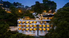Evening view of the illuminated hillside property at Pride Ashiyana Resort Mussoorie.