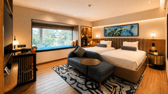 Spacious bedroom at Pride Premier Pune with twin beds, seating area and large picture window.