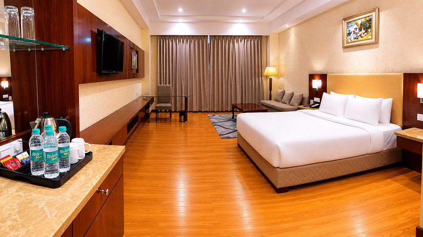 A room at HHI Varanasi featuring, a large bed, spreads, pillows, a television, and other toileteries.