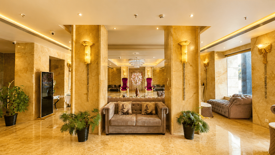 Elegant hotel lobby at Golden Tulip Kukas Jaipur with a seating area, decorative columns, indoor plants, warm lighting, and a welcoming ambience.