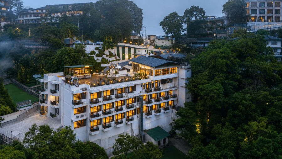 Aerial view of the hillside property surrounded by greenery at Pride Ashiyana Resort Mussoorie.