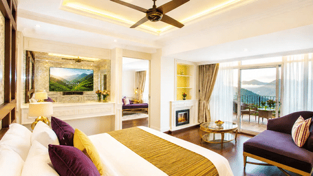 Wild Orchid Suite at Fragrant Nature Munnar with purple and gold decor, fireplace, seating area, and private balcony overlooking the hills