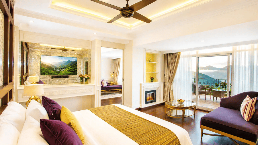 Wild Orchid Suite at Fragrant Nature Munnar with purple and gold decor, fireplace, seating area, and private balcony overlooking the hills