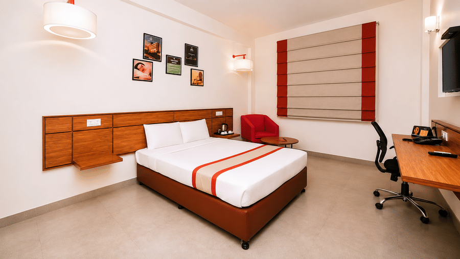 Max Queen Room at Max Hotel Jabalpur featuring a queen size bed, work desk, air conditioner and contemporary interiors.