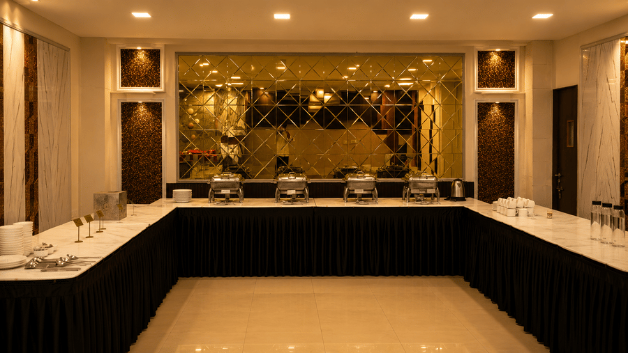 An illuminated dining space with an elongated table and vessels at The Pamposh, New Delhi.