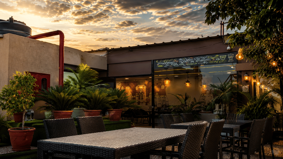 The Pamposh, New Delhi | A rooftop resturant with plants and a table set for dining