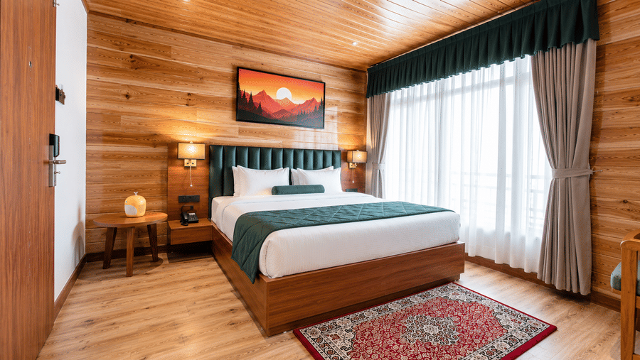 Bedroom featuring a king size bed, large window, and bedside table at Valmere Lungta Boutique Hotel & Spa, Darjeeling.