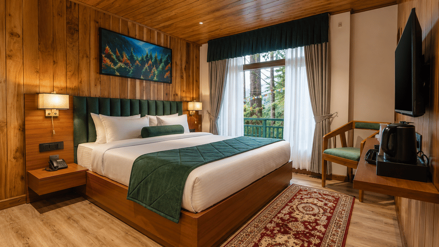 Bedroom with a king size bed, wooden walls, and framed painting at Valmere Lungta Boutique Hotel & Spa, Darjeeling.