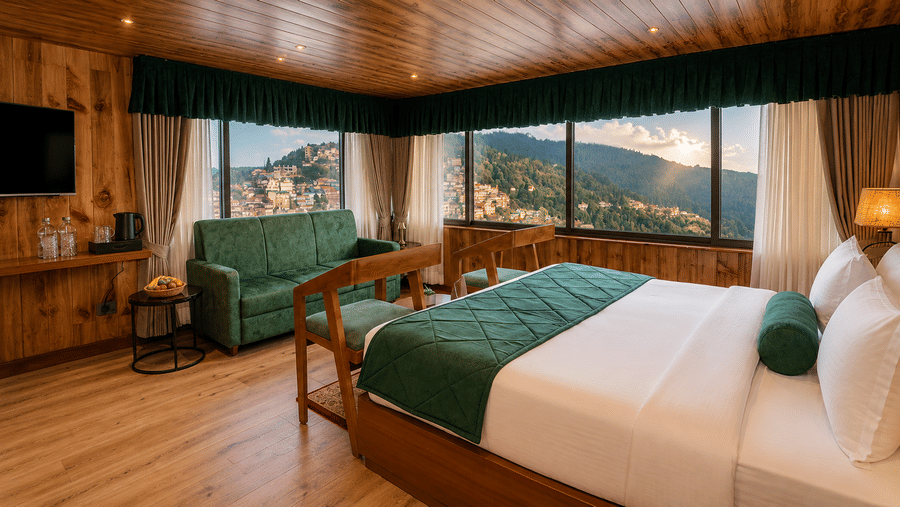 Bedroom suite with a king size bed, corner sofa, and corner windows at Valmere Lungta Boutique Hotel & Spa, Darjeeling.