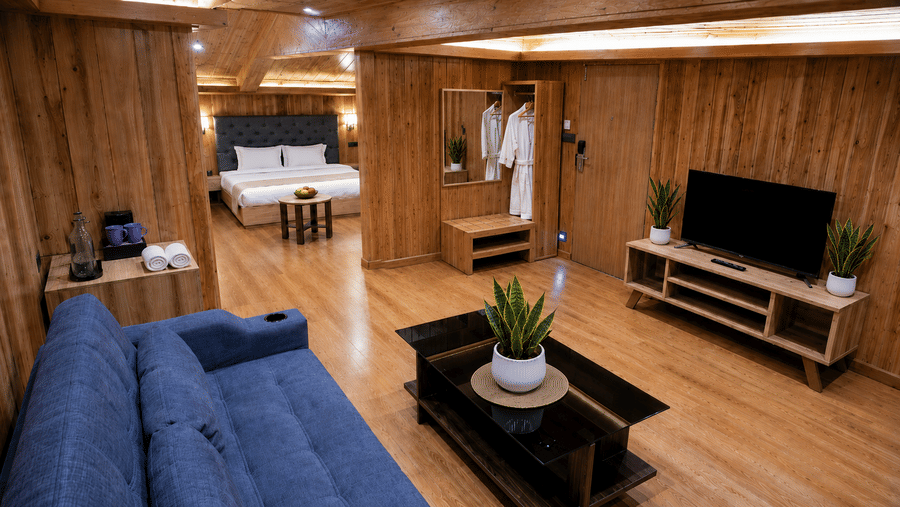 Attic Suite at Valmere Magnolia Boutique Hotel & Spa, Pelling with a wooden TV unit, potted plants, an open wardrobe with robes, and a view to the bedroom.