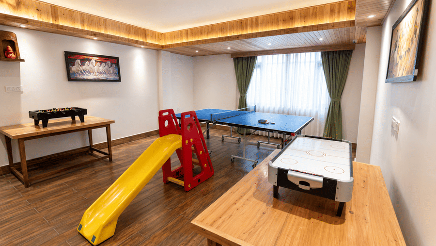 Indoor game room at Valmere Magnolia Boutique Hotel & Spa, Pelling with a table tennis table, foosball table, air hockey table, and a children's slide.