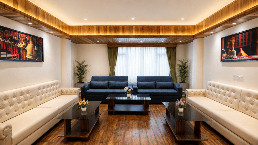 Lounge at Valmere Magnolia Boutique Hotel & Spa, Pelling with 2 cream tufted sofas facing a navy blue sofa, wooden coffee tables, and framed photographs.
