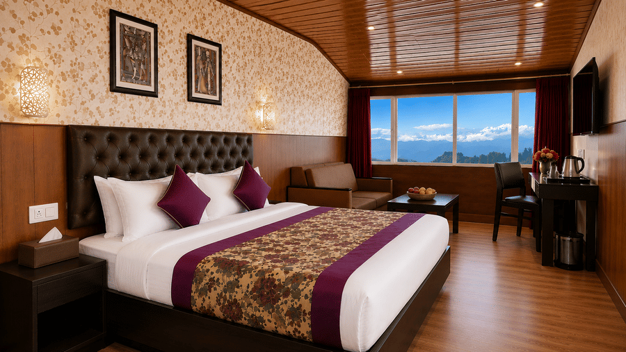 Premium Room at Valmere Thistle Boutique Hotel, Darjeeling with a king bed, wall-mounted TV, a desk with a kettle, and snow-capped mountain views.