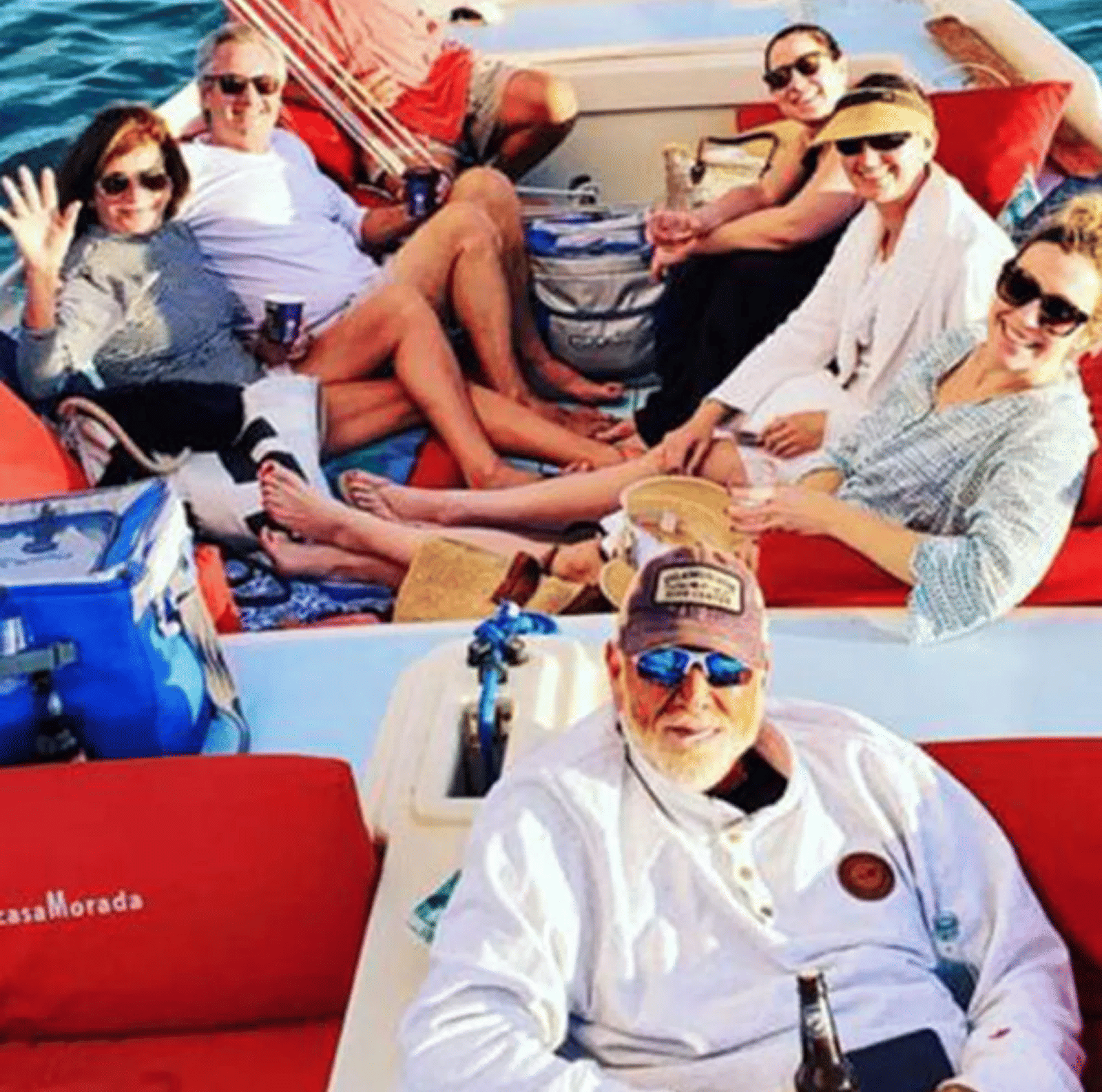 A top-angle shot of a family siting leisurely on a boat with the sun rays falling on them radiating their faces.