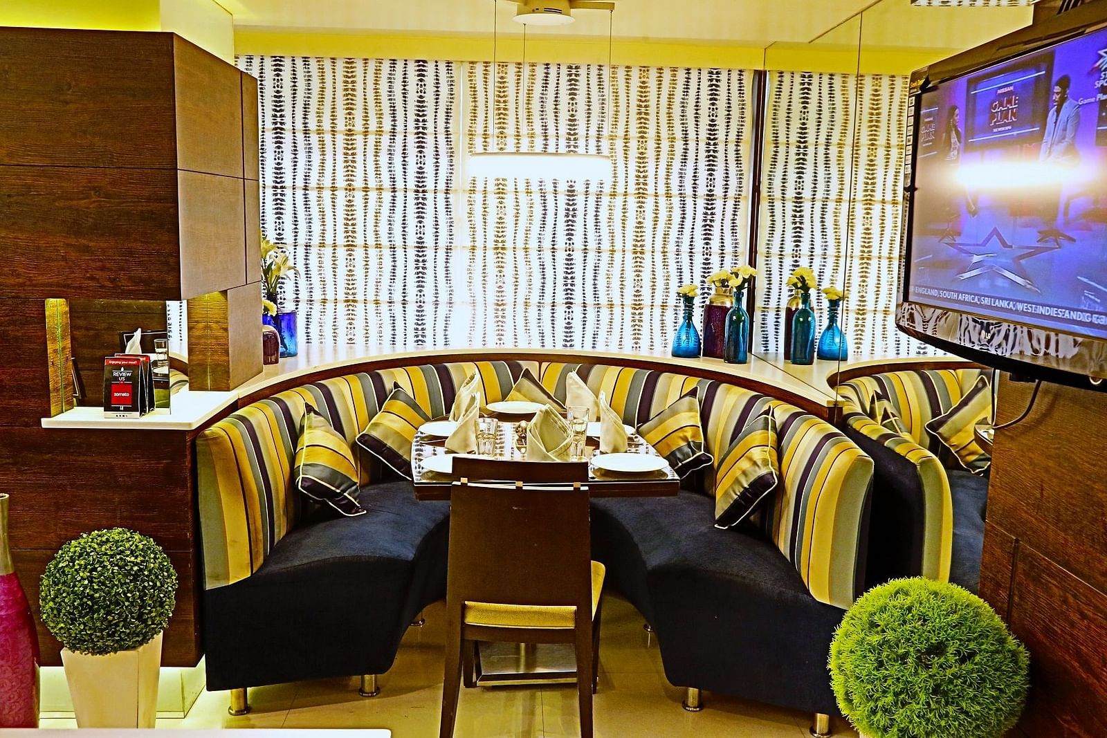 Image of a dining corner with sofas and plants on the side  at The Oriental Residency