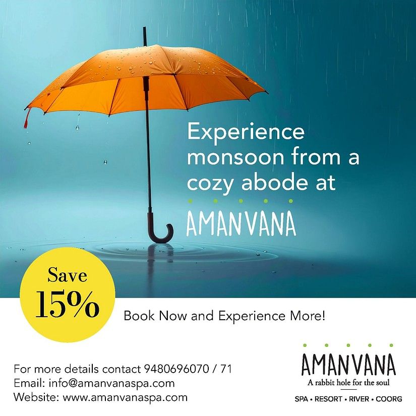 Orange umbrella in rain with water droplets against blue sky, advertising Amanvana Spa Resort, Coorgs monsoon experience with 15% discount offer