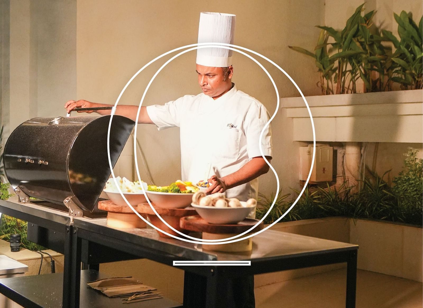 A chef in his attire preparing a counter with various well-plated dishes.