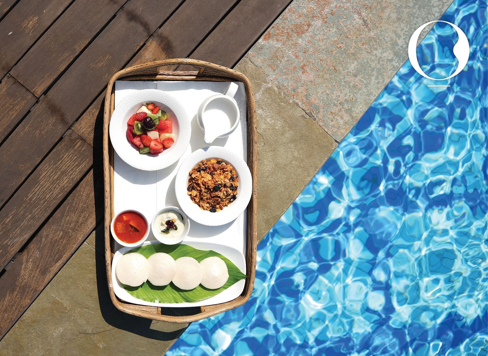 Top angle shot of a tray kept on the poolside at Miros Hotels serving breakfast by the pool.