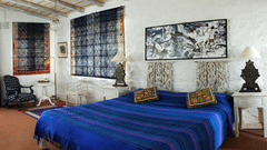 A spacious room with king size bed and bedside lamp - Ramgarh Bungalows, Nainital.