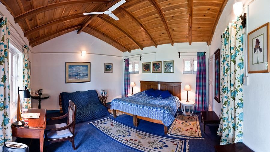 Irish room with a work desk and featuring a couch beside a queen size bed - Ramgarh Bungalows, Nainital.